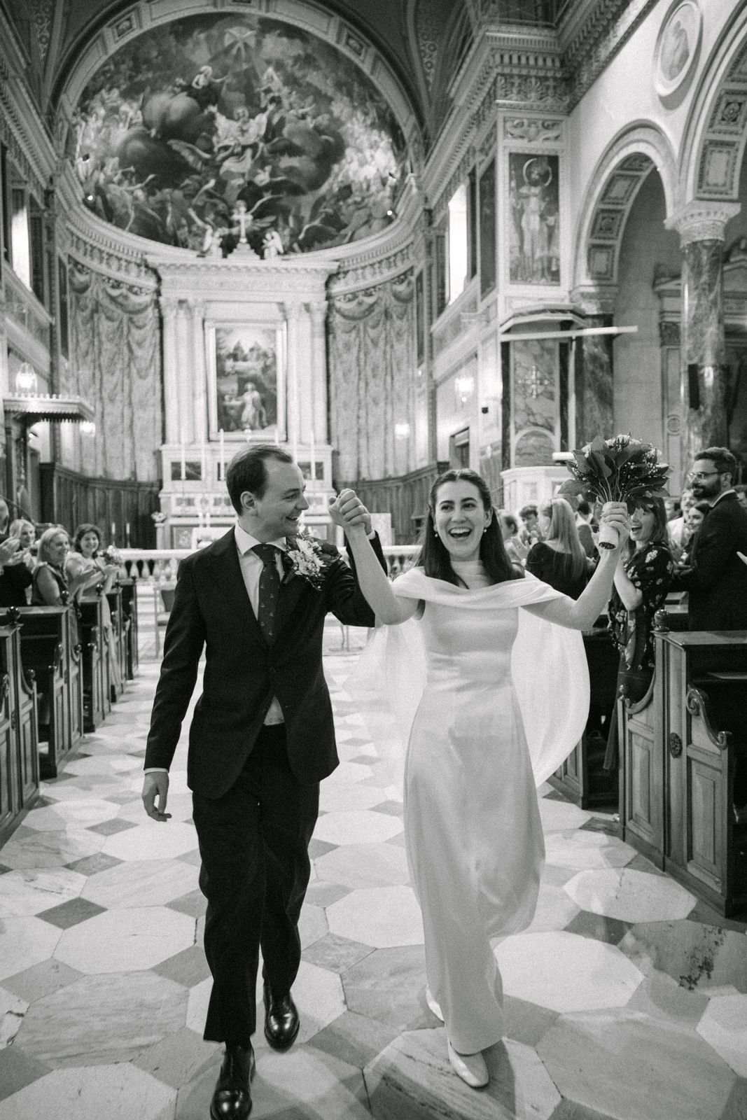 A couple walking out of the cathedral in Athens after their wedding, black and white